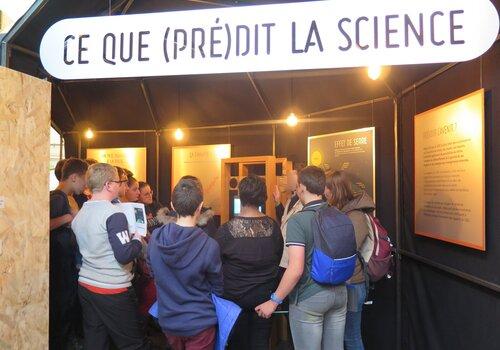 "Ce que prédit la science", photographie d'une partie de l'exposition avec public