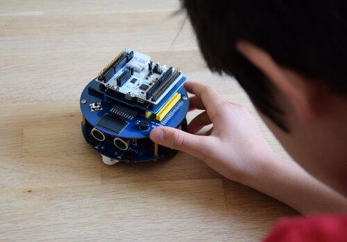 petit robot type rover manipulé par un enfant