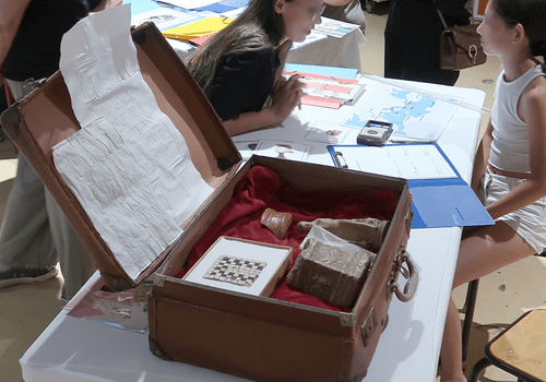 Valise dans la quel on retrouve différents objet lier à l'archéologie, comme un morceau de vase, un statuette, des moulage de texte antique etc.