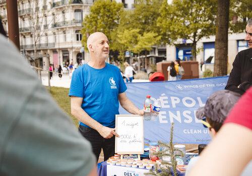 Une personne se trouve devant la banderole de l'association