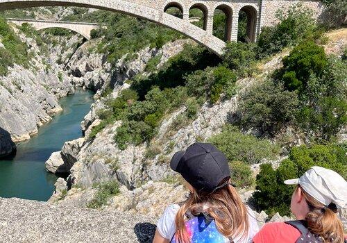 Deux enfants regardant le pont du diable et l'Hérault