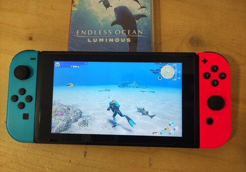 Une console switch sur laquelle joue le jeu vidéo « Endless Ocean Luminous »