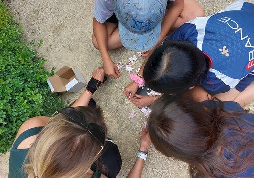 Enfants photogrpahiés en plongée en train de faire un puzzle sur le so