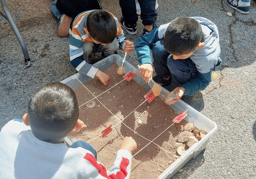 enfants qui fouillent à la recherche de fossiles