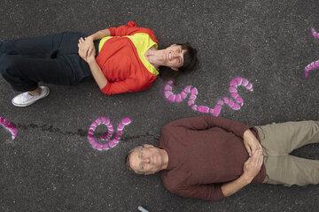 Le duo d'artistes Giacomo Sartori & Elena Tognoli, allongés au sol souriant.