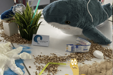 Image d'un requin en peluche entouré de divers déchets plastiques.